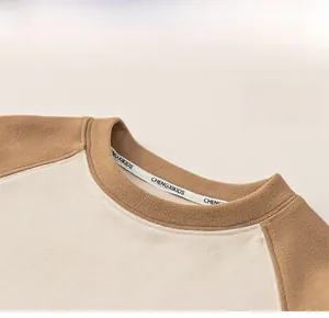 Détail d'un sweat-shirt à col rond pour enfant montrant la texture polaire bicolore