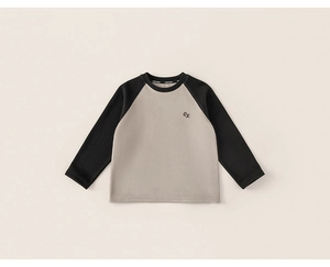 Détail d'un t-shirt à manches raglan pour enfant montrant le petit logo sur la poitrine