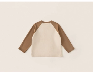 Gros plan du t-shirt raglan pour enfants avec coutures fines et texture en coton doux