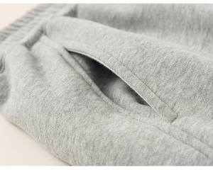 Détail du jogging tricoté gris pour enfant avec taille élastique et texture de poche