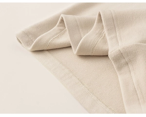 Gros plan des coutures de manches raglan beige et de la texture du tissu polaire