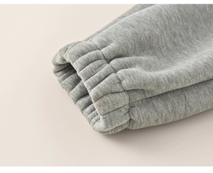 Vue macro détaillée des poignets côtelés gris sur un pantalon thermique épais pour enfant