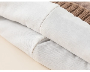 Close-up of brown ribbed knit exterior and soft white lining with neat stitching