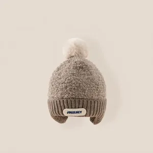 Cozy winter knit trapper hat for kids with soft faux fur pom-poms and warm ear flaps