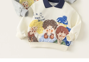 Close-up of cream-colored kids' cotton hoodie with blue polo collar and cartoon print
