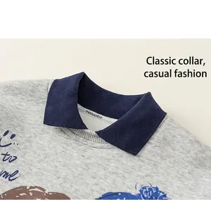 Detail of grey polo collar sweatshirt featuring blue contrast neck and cartoon prints