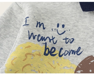 Close-up of soft grey knitted fabric with playful cartoon graffiti and blue lettering