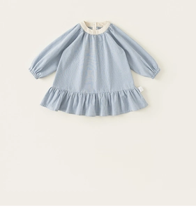 Dettaglio vestito bambina a quadretti blu con colletto a contrasto e bordo con volant