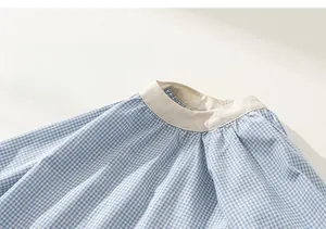 Dettaglio dello scollo dell'abito a quadretti bianchi e blu per bambina con bordo