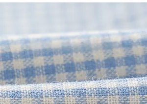 Dettaglio della trama del tessuto scozzese blu e bianco per vestito in cotone da bambina