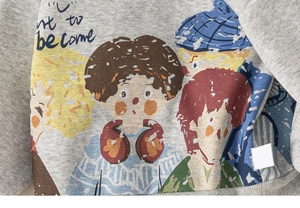 Detail of grey fleece sweatshirt featuring colorful cartoon characters and text print