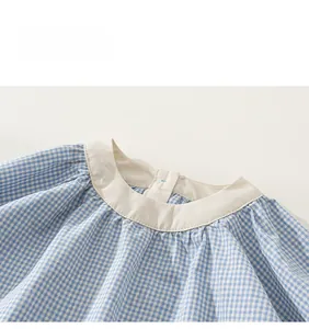 Dettaglio del vestito a quadretti blu e bianchi per bimba con colletto tondo e bottone