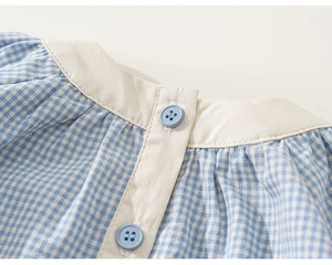 Dettaglio del colletto a quadretti blu con tessuto beige a contrasto e bottoni blu