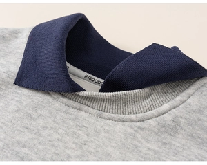 Close-up of the grey kid's sweatshirt collar with navy blue double-layered lapel design