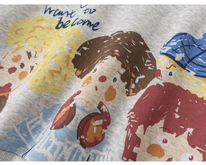 Detail of cartoon illustration print and text on grey cotton sweatshirt for boys