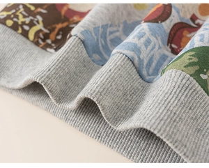 Detailed macro view of the grey ribbed cuffs and colorful printed fabric on kids sweatshirt