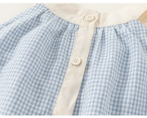 Detailed view of blue gingham cotton fabric and beige collar with white buttons