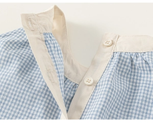 Detail of blue and white checkered girl's dress neckline with ivory buttons and stitching