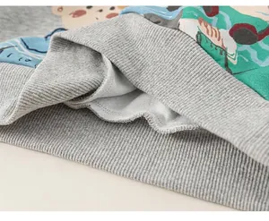 Macro detail of kids sweatshirt showing gray ribbed hem and warm white fleece lining