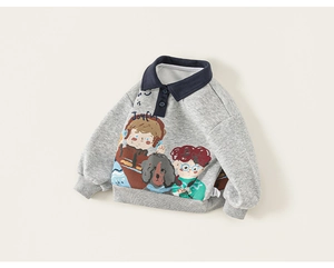 Detail of children's grey polo sweatshirt featuring cartoon graffiti prints and navy collar