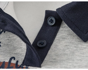 Detailed macro view of the polo collar stitching and navy blue button placket on kid's sweatshirt