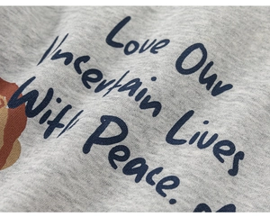 Macro detail of grey knitted cotton fabric with navy Love Our Uncertain Lives text print