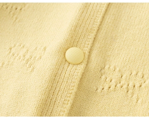 Close-up of lemon yellow knitted cardigan featuring hollow mesh and matching button