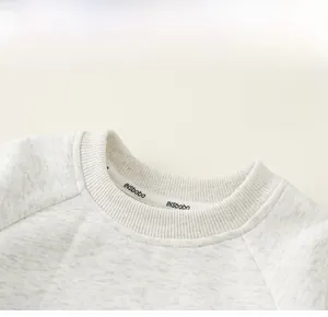 Detail of the crew neck and raglan sleeve stitching on the light grey kids sweatshirt