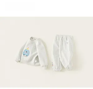 Flat lay of gray children's tracksuit featuring a blue cartoon monster and matching joggers