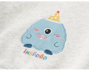 Close-up of cute blue monster towel embroidery and Insbobo lettering on gray sweatshirt