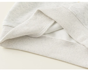 Detailed view of light gray ribbed hem and inner fabric texture of kids' sweatshirt
