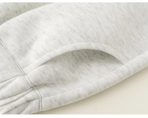 Close-up detail of pocket stitching on light grey cotton knit sweatshirt for children