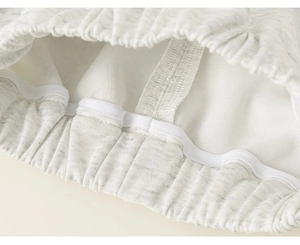 Close-up of elastic waistband with reinforced stitching on gray knitted trousers