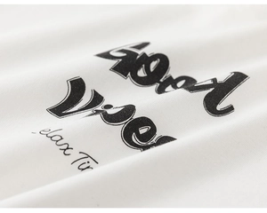 Macro shot of cotton fabric texture with Good Vibes typography on a white t-shirt