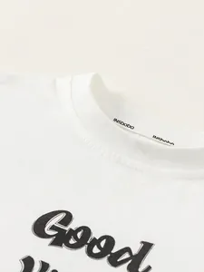 Close-up of boys' white long-sleeve cotton T-shirt with black Good letter print