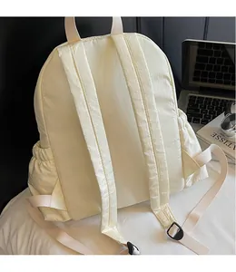 Detail of adjustable padded shoulder straps on a lightweight cream nylon backpack