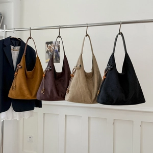 Dettaglio di grandi borse tote in ecopelle scamosciata in vari colori con nappe di perline