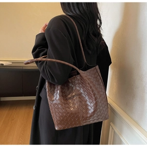 Detailed close-up of dark brown woven tote bag showcasing leather texture and craftsmanship