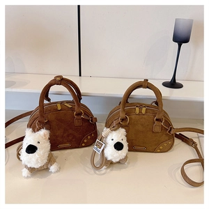 Detail view of retro suede bowling bags with golden zippers and cute plush dog charms