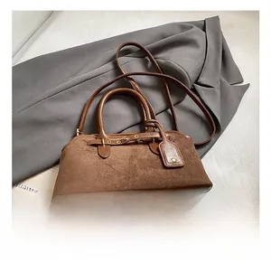 Détail du sac à main vintage en cuir dépoli marron avec poignées rondes et métal