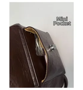 Detail eines braunen Vintage-Rucksacks mit Mini-Tasche und silbernem Drehverschluss-Detail
