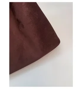 Dettaglio del tessuto scamosciato marrone scuro con texture opaca e materiale spesso