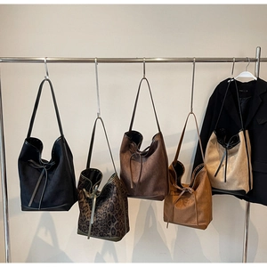 Détails de grands sacs cabas en daim déclinés en cinq coloris et imprimé léopard sauvage