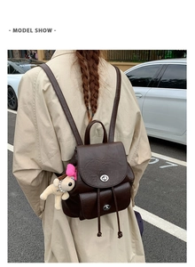 Detail eines braunen Vintage-Rucksacks aus PU-Leder mit Kordelzug und Plüschhund-Anhänger