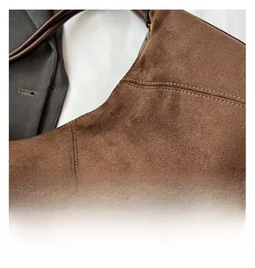 Detailed close-up of brown suede fabric with professional double stitching on bag