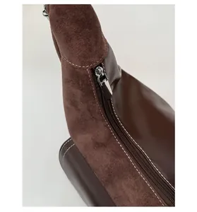 Detail shot of vintage dark brown suede and smooth leather stitching with silver zipper