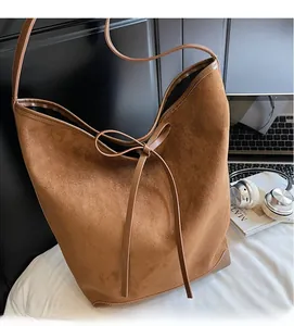 Vue détaillée du sac cabas en daim marron avec un ruban décoratif en cuir noué en nœud