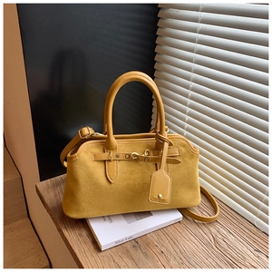 Détails de la texture en daim jaune moutarde et de la boucle en métal du sac à main