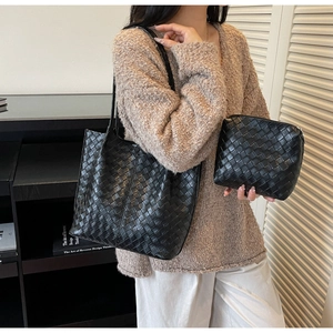 Detail showing black woven faux leather texture on large tote bag with matching pouch