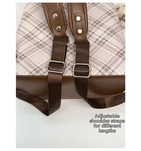 Detail of adjustable shoulder straps with silver buckles on a plaid backpack